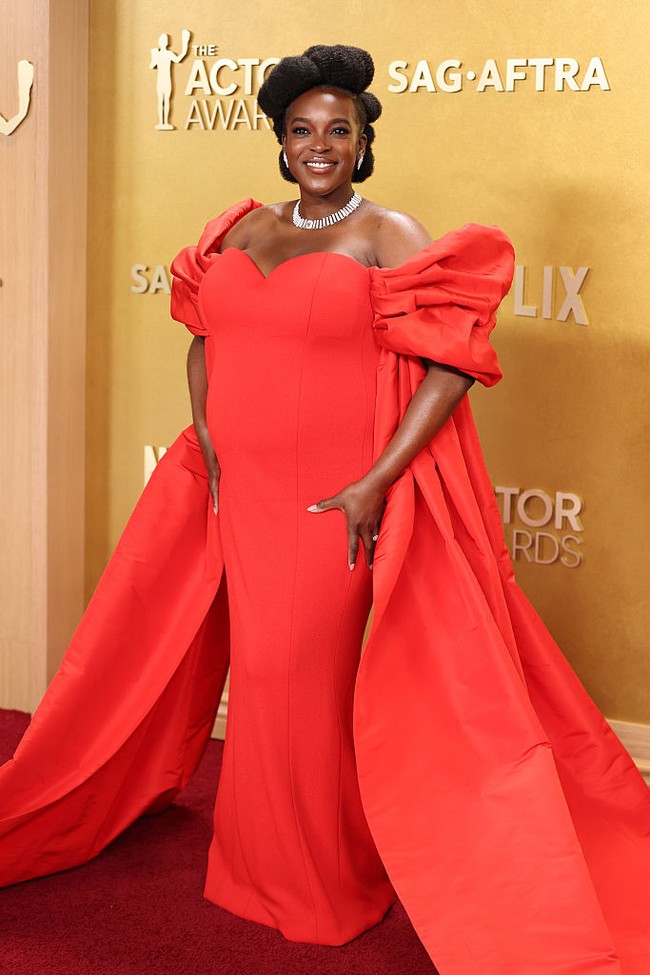 Wunmi Mosaku memakai gaun merah custom berbahan jersey dari Louis Vuitton dengan lengan silk taffeta yang sukses menciptakan siluet dramatis sekaligus anggun. (Foto: Kevin Mazur/Getty Images)