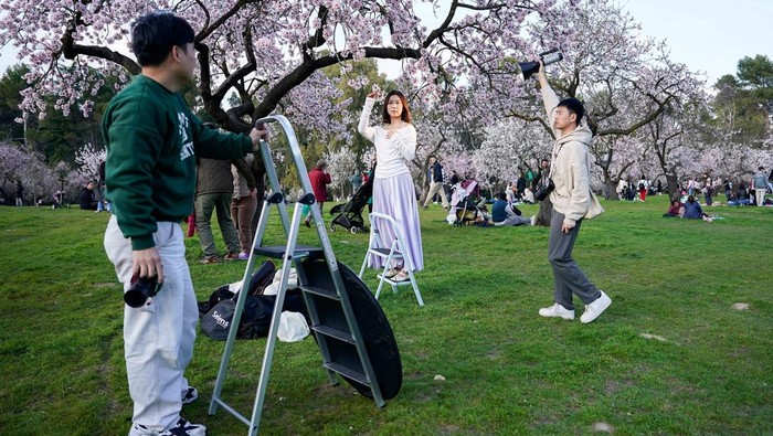 People spend time outside amongst blooming almond trees at Quinta de los Molinos park in Madrid, Spain, March 1, 2026. REUTERS/Ana Beltran       TPX IMAGES OF THE DAY