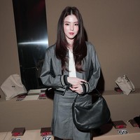 Saat tiba di venue, Han So Hee tampil dalam balutan varsity jacket abu-abu dengan detail stripes pada bagian ujung lengannya, berpadu dengan setelan rok abu-abu berwarna senada. Foto: Getty Images