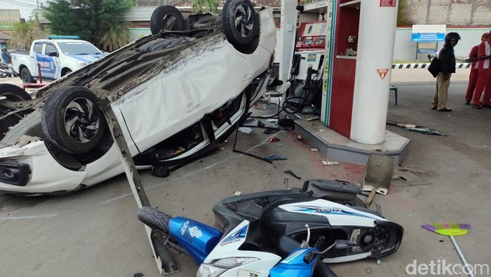 Mobil Honda Mobilio hilang kendali hingga terbang dan menyeruduk dispenser SPBU serta pemotor yang tengah antre BBM.