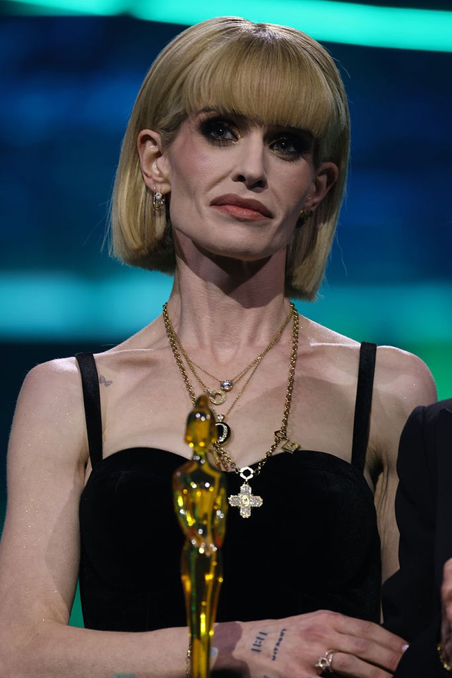 Ia sempat mengenakan bolero berbulu hitam sebelum melepasnya, yang justru semakin menonjolkan bentuk tubuhnya yang sangat ramping. Foto: Getty Images/JMEnternational