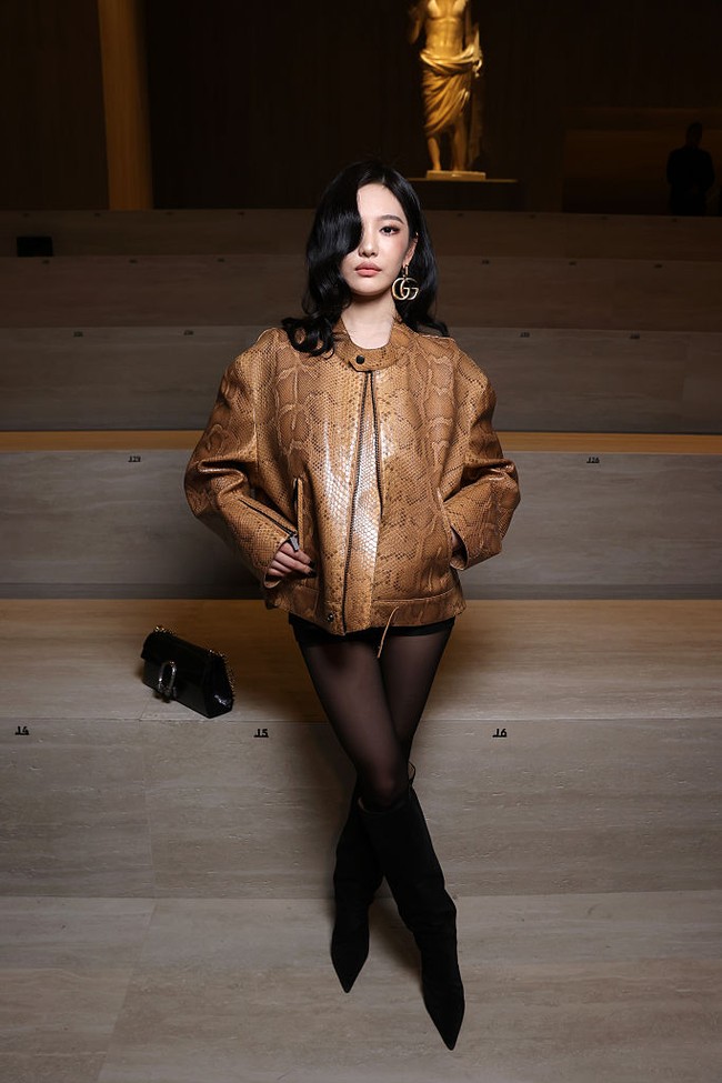 Gaya Ningning aespa dilengkapi dengan stocking hitam, handbag, serta boots yang mempertegas kesan bold dan elegan. Foto: Getty Images