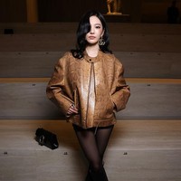 Gaya Ningning aespa dilengkapi dengan stocking hitam, handbag, serta boots yang mempertegas kesan bold dan elegan. Foto: Getty Images