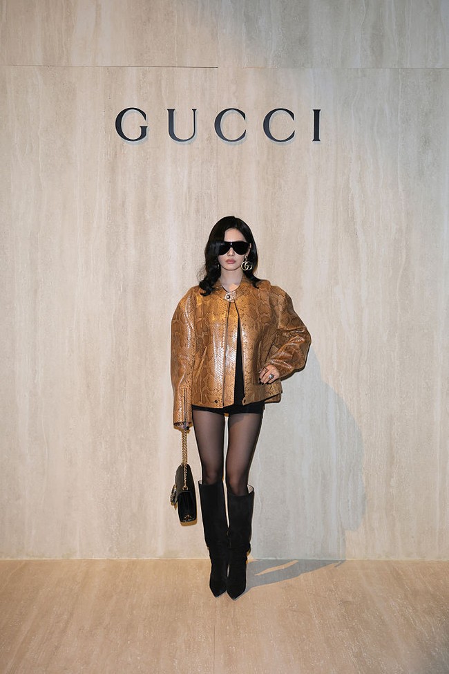 Saat tiba di venue, ia memancarkan aura girl boss lewat leather jacket motif kulit ular dan mini dress hitam. Kacamata hitam dan anting-anting Gucci yang dikenakan Ningning aespa juga menjadi fashion statement. Foto: Getty Images