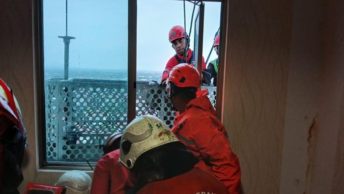 Evakuasi pekerja pembersih kaca yang terjebak saat hujan badai di apartemen Ascott