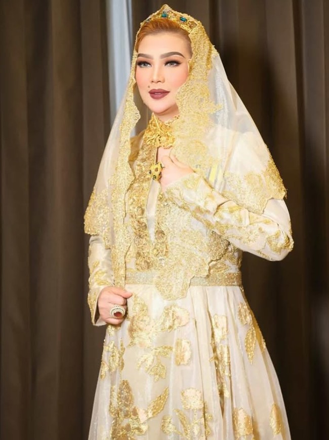 Kali ini Syarifah mengenakan busana formal bernuansa emas dan batik. Senyum sumringah dan riasan bibir berwarna merah gelap memberikan kesan berwibawa sekaligus glamor sebagai istri pejabat. Foto: Dok. Instagram @syarifahsuraidah.