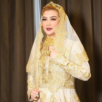 Kali ini Syarifah mengenakan busana formal bernuansa emas dan batik. Senyum sumringah dan riasan bibir berwarna merah gelap memberikan kesan berwibawa sekaligus glamor sebagai istri pejabat. Foto: Dok. Instagram @syarifahsuraidah.
