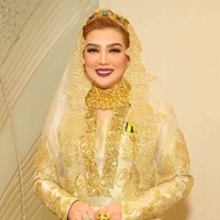 Tampil bak ratu, ia mengenakan gaun pengantin penuh payet berwarna emas yang glamor lengkap dengan headpiece yang berkilau. Detail bordir yang rumit pada seluruh busananya menunjukkan selera fashion yang menjadi pusat perhatian. Foto: Dok. Instagram @syarifahsuraidah.
