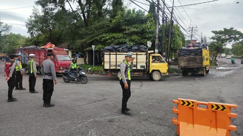 Petugas kepolisian pada saat melakukan pengamanan arus lalin sejak TPA Suwung beroperasi kembali, Senin (2/3/2026).