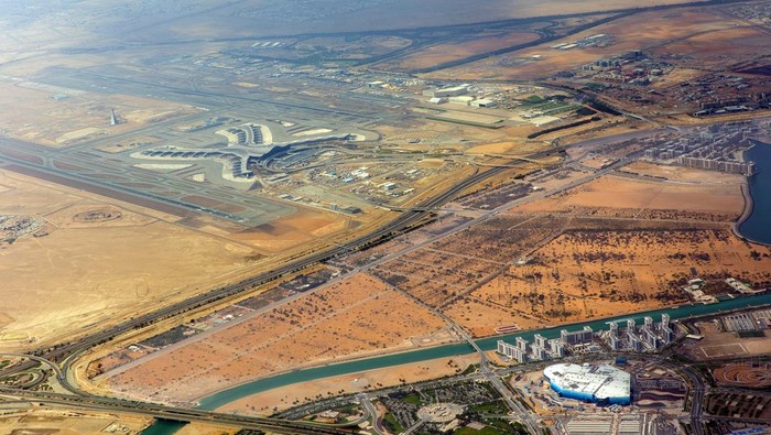 Pemandangan pesawat Bandara Internasional Abu Dhabi, jalan-jalan, jalan-jalan dan bangunan tempat tinggal kota