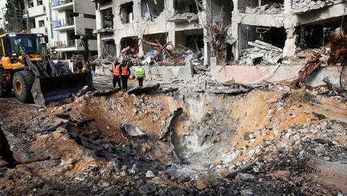 Emergency personnel stand at the site of an Iranian missile strike on a residential building, after Iran launched missile barrages following attacks by the U.S. and Israel on Saturday, in Tel Aviv, Israel March 1, 2026. REUTERS/Ronen Zvulun