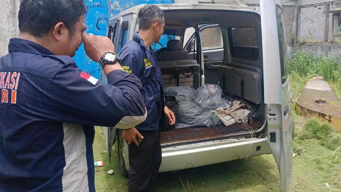 Petugas Tim Inafis Satreskrim Polres Cimahi mengevakuasi 2 mayat yang ditemukan di dalam mobil