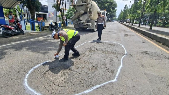 Petugas Satlantas Polres Nganjuk menandai jalan rusak untuk sambut arus mudik