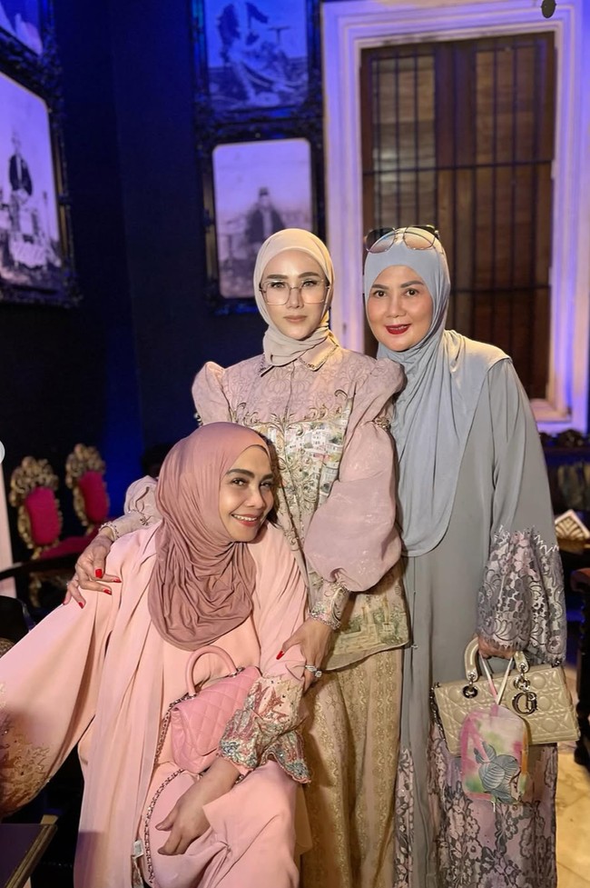 Mulan tampil anggun dengan busana bernuansa dusty pink. Atasan lengan balon transparan dipadukan dengan celana panjang bahan senada. Ia melengkapi penampilannya dengan hijab polos yang juga berwarna senada. Foto: Instagram/@rieta_amilia