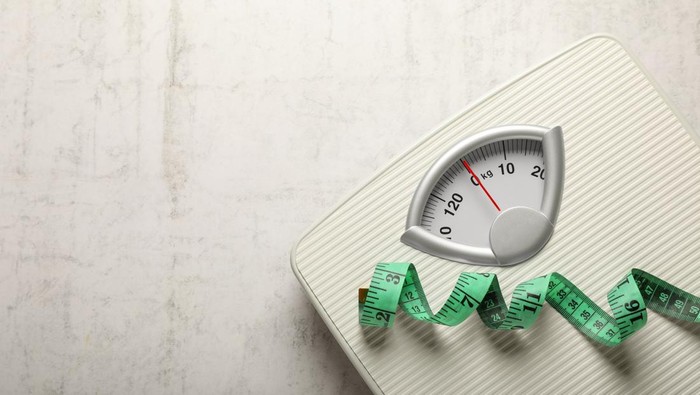 Weigh scales and measuring tape on white textured background, top view with space for text. Overweight concept