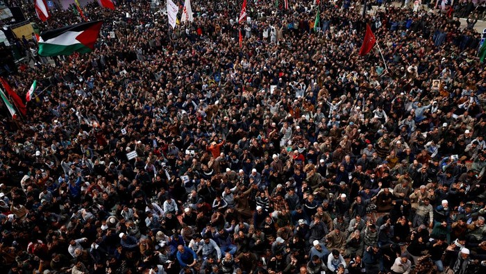 A Shi'ite Muslim woman holds a wooden hoop frame with a hand-embroidered figure of Iran’s Supreme Leader Ayatollah Ali Khamenei, during a demonstration following the killing of Khamenei in U.S. and Israeli strikes on Saturday, in Magam town, Indian Kashmir, March 4, 2026. REUTERS/Sharafat Ali