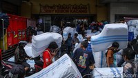 Para pekerja memanggul karung seberat puluhan kilogram menuju titik pengumpulan, sebelum akhirnya ditumpuk ke dalam truk-truk ekspedisi yang telah menunggu di area bongkar muat.