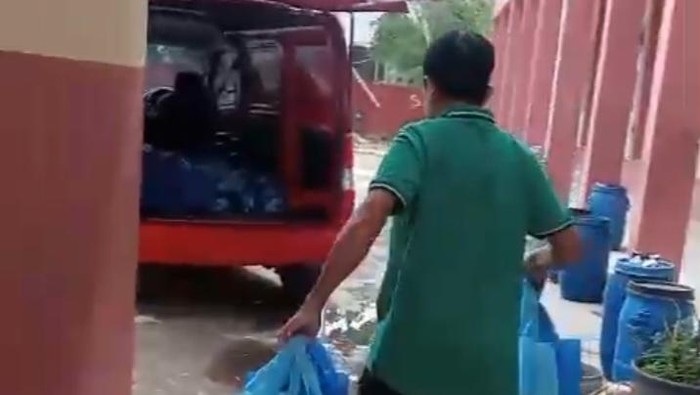 Salah seorang guru di Majalengka saat mengembalikan paket MBG.