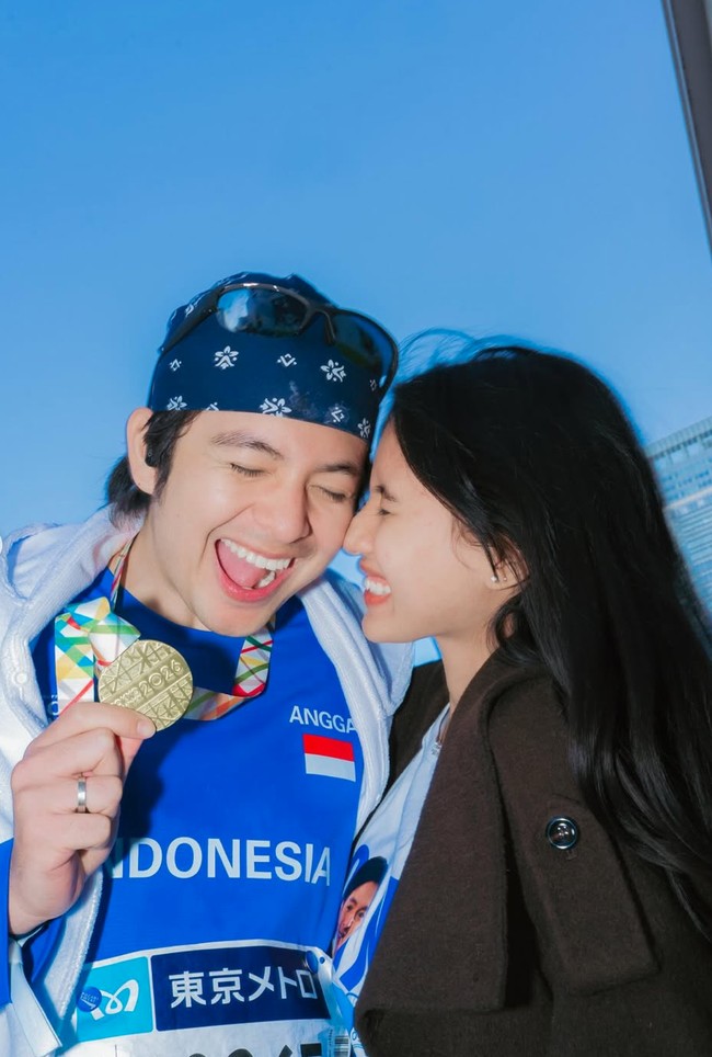 Pamer kebucinan, di balik coat yang dikenakan Shenina rupanya terdapat kaos dengan sablon foto wajah Angga Yunanda. Foto: Instagram/@sheninacinnamon