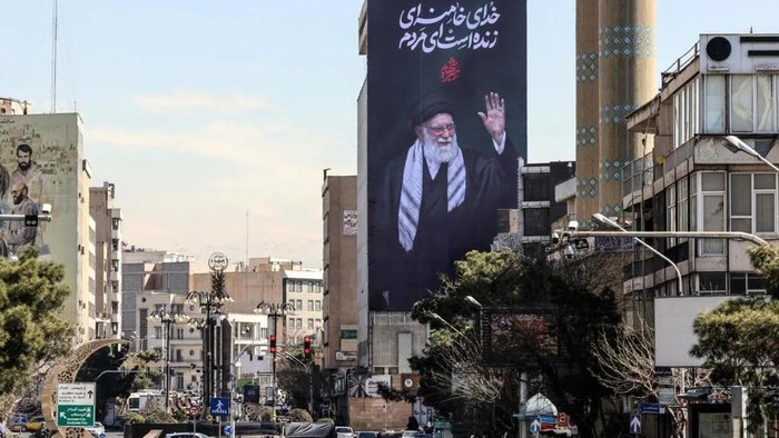 Situasi Teheran, ibu kota Iran, dengan foto mendiang Khamenei terpasang pada sebuah billboard (AFP) 