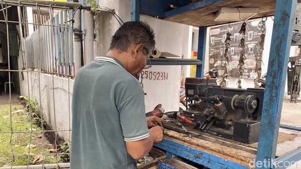 Ujang, Ahli Kunci yang sedang mengerjakan duplikasi kunci di lapaknya