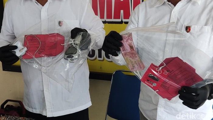 Petugas menunjukkan alat pijat elektrik dan uang hasil penjualan cincin emas yang didapat usai menipu nenek di Moyudan, Sleman, Kamis (5/3/2026).