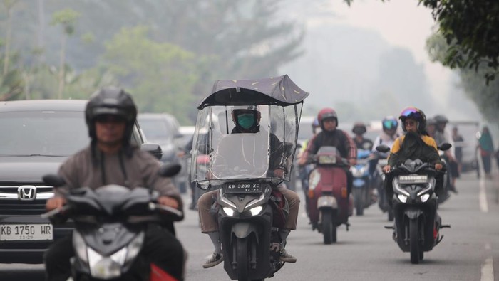 Sejumlah pengendara motor melintasi jalan yang diselimuti kabut asap di Pontianak, Kalimantan Barat, Kamis (5/3/2026). Berdasarkan pantauan BMKG Kalbar menggunakan sensor VIIRS dan MODIS pada satelit polar per 4 Maret 2026, terdeteksi 206 titik panas akibat kebakaran hutan dan lahan di sejumlah kabupaten di Kalimantan Barat, yaitu antara lain Mempawah, Ketapang, Bengkayang, Sambas, Kubu Raya, serta Pontianak. ANTARA FOTO/Jessica Wuysang/foc.