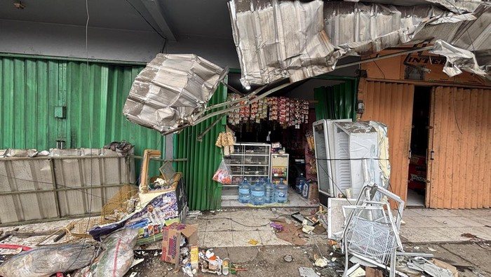Truk tronton bermuatan galon air terguling di Bekasi, menimpa warung dan ruko. (Rachma Indira/detikcom)