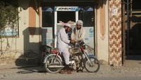 Warga membeli bensin yang didatangkan dari Iran di kios dan depot pinggir jalan di Quetta, Pakistan, Rabu (4/3/2026). REUTERS/Naseer Ahmed  