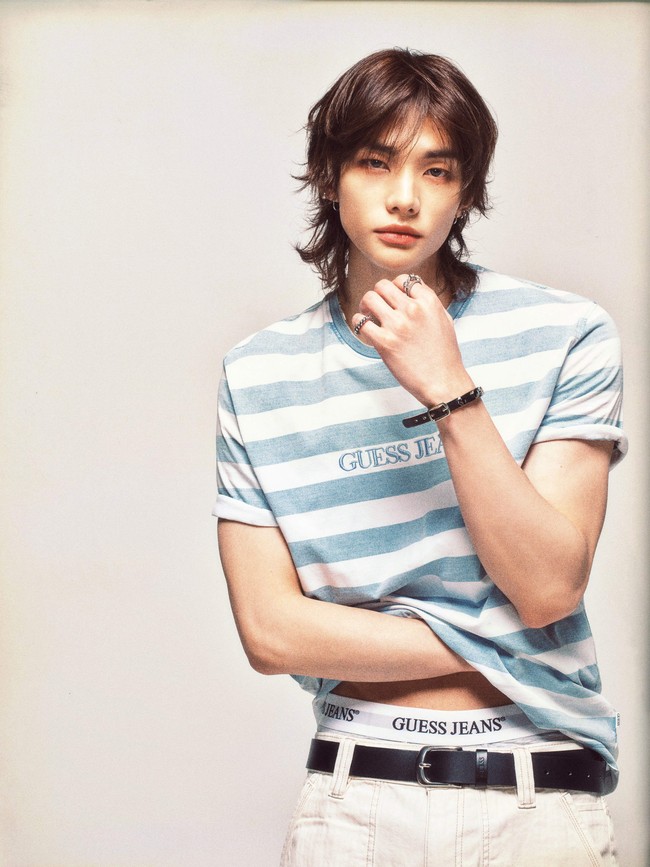Pria 25 tahun ini tampil stylish dengan busana casual yang memadukan T-shirt motif garis dan jeans putih. Boxer yang ‘mengintip’ jadi statement gaya Hyunjin yang kerap berpenampilan edgy. Foto: Dok. GUESS