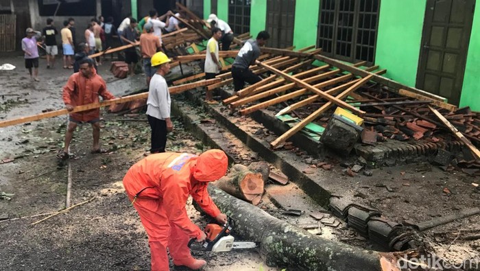 Warga dan BPBD Boyolali memotong pohon yabg menimpa teras rumah warga di Kemiri, Mojosongo, Boyolali, Jumat (6/3/2026) sore.
