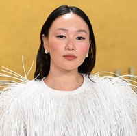 Makeup natural dengan kompleksi glowing, eyeliner hitam tegas, serta lipstik nuansa nude-pink memberi kesan segar. Rambut panjangnya ditata bergelombang ringan dengan belahan tengah, lalu diselipkan di belakang telinga sehingga memberi kesan santai namun tetap rapi. Foto: Deadline via Getty Images/Earl Gibson III
