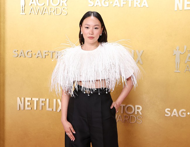 Busana yang dikenakannya terdiri dari celana hitam high-waist dengan potongan lurus dan detail lipit yang memberikan siluet rapi. Celana tersebut dipadukan dengan crop top putih lengan pendek dengan struktur bahu tegas. Foto: Variety via Getty Images/JC Olivera