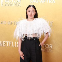 Busana yang dikenakannya terdiri dari celana hitam high-waist dengan potongan lurus dan detail lipit yang memberikan siluet rapi. Celana tersebut dipadukan dengan crop top putih lengan pendek dengan struktur bahu tegas. Foto: Variety via Getty Images/JC Olivera