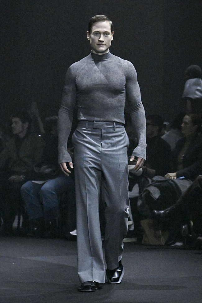 Menandai debutnya sebagai model di Paris Fashion Week, miliuner asal Amerika Serikat itu memeragakan satu set busana serba abu-abu. Atasannya berupa turtleneck sweater versi ketat yang mempertegas torso atletis Bryan. (Foto: Victor VIRGILE/Gamma-Rapho via Getty Images)