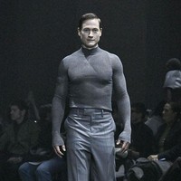 Menandai debutnya sebagai model di Paris Fashion Week, miliuner asal Amerika Serikat itu memeragakan satu set busana serba abu-abu. Atasannya berupa turtleneck sweater versi ketat yang mempertegas torso atletis Bryan. (Foto: Victor VIRGILE/Gamma-Rapho via Getty Images)