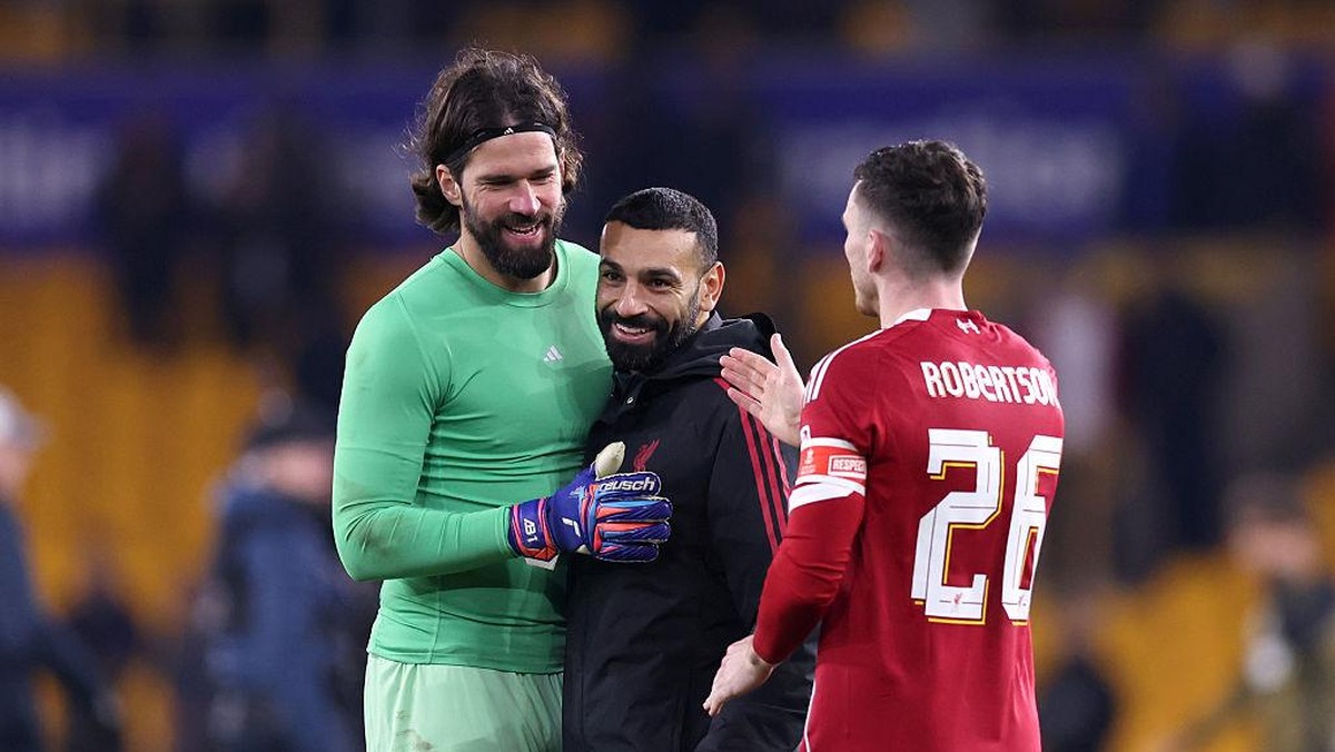 Alisson (kiri), Salah (tengah), dan Robertson merayakan kemenangan Liverpool atas Wolves di Piala FA. Foto: Getty Images/Alex Livesey
