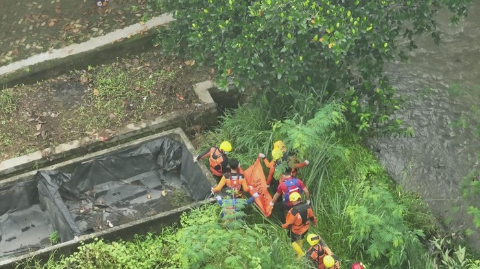 Petugas mengevakuasi jasad anak 10 tahun yang hanyut saat banjir landa Bandar Lampung