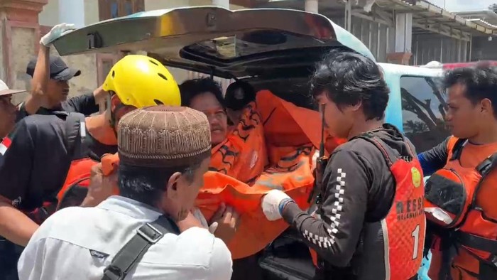Petugas mengevakuasi jasad anak yang hilang terseret banjir di Lampung
