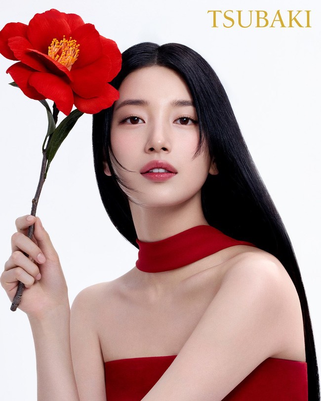 Dalam foto yang dirilis, Suzy menampilkan keanggunan dalam balutan gaun dan bunga camellia merah, yang menjadi bahan utama produk ini. Foto: dok. Instagram @skuukzky