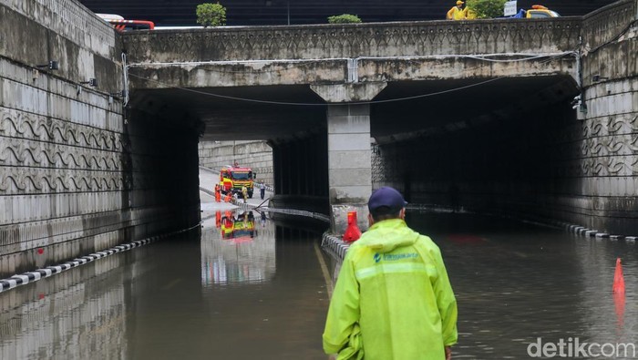 Petugas menangani banjir yang menggenangi Underpass Mampang, Jakarta, Minggu (8/3/2026). Genangan air yang terjadi sejak pagi hari membuat akses jalan di jalur tersebut terpaksa ditutup sementara bagi para pengguna kendaraan.