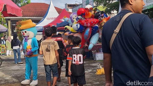Salah satu badut berkeliaran di titik sentra kuliner takjil di Pagutan, Kota Mataram, Minggu (8/3/2026). Nathea Citra/detikBali