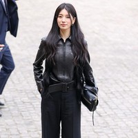 Untuk penampilannya di Paris Fashion Week 2026, Suzy memancarkan aura ‘misterius’ dalam balutan all black outfit. Ia memakai biker jacket dengan aksen belt, wide leg pants, pointed-toe heels, dan koleksi tas Halfmoon Soft Triomphe. Foto: dok. X