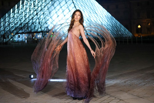 Desainer asal Belanda itu dikenal lewat karya-karya couture futuristik dan sculptural yang menonjolkan ilusi gerak serta bentuk yang kerap terlihat menantang gravitasi. Adapun gaun berwarna peach yang dipakai perempuan blasteran AS-China itu hadir dengan fitur berupa sayap dramatis.  Foto: Stephane Cardinale - Corbis/Corbis via Getty Images