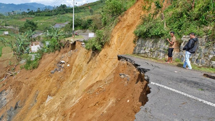 Warga menyaksikan jalan longsor di kawasan dataran tinggi Dieng Desa Ratamba, Pejawaran, Banjarnegara, Jawa Tengah, Minggu (8/3/2026). Akibat hujan deras jalan raya menuju kawasan wisata Dieng lewat Pejawaran putus total, warga yang hendak menuju Dieng atau sebaliknya terpaksa harus memutar melalui jalur lain dengan jarak tempuh sejauh 15 kilometer. ANTARA FOTO/Anis Efizudin/foc.