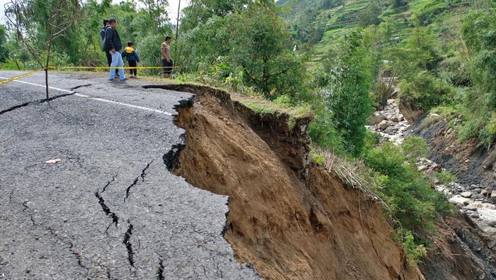 Warga menyaksikan jalan longsor di kawasan dataran tinggi Dieng Desa Ratamba, Pejawaran, Banjarnegara, Jawa Tengah, Minggu (8/3/2026). Akibat hujan deras jalan raya menuju kawasan wisata Dieng lewat Pejawaran putus total, warga yang hendak menuju Dieng atau sebaliknya terpaksa harus memutar melalui jalur lain dengan jarak tempuh sejauh 15 kilometer. ANTARA FOTO/Anis Efizudin/foc.