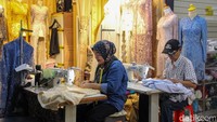 Beberapa penjahit terlihat fokus menyelesaikan pesanan dengan mengukur kain, memotong pola, hingga menjahit pakaian.  