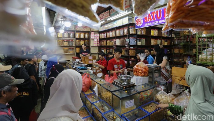 Pedagang kue kering dan kue lebaran melayani pembeli yang dijual di Pasar Jatinegara, Jakarta, Senin (9/3/2026). Menurut pedagang, dua pekan menjelang Lebaran penjualan kue kering tersebut mulai banyak dibeli seperti kue nastar, kue lidah kucing, dan kue putri salju.