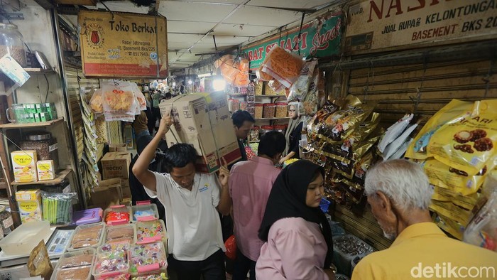 Pedagang kue kering dan kue lebaran melayani pembeli yang dijual di Pasar Jatinegara, Jakarta, Senin (9/3/2026). Menurut pedagang, dua pekan menjelang Lebaran penjualan kue kering tersebut mulai banyak dibeli seperti kue nastar, kue lidah kucing, dan kue putri salju.