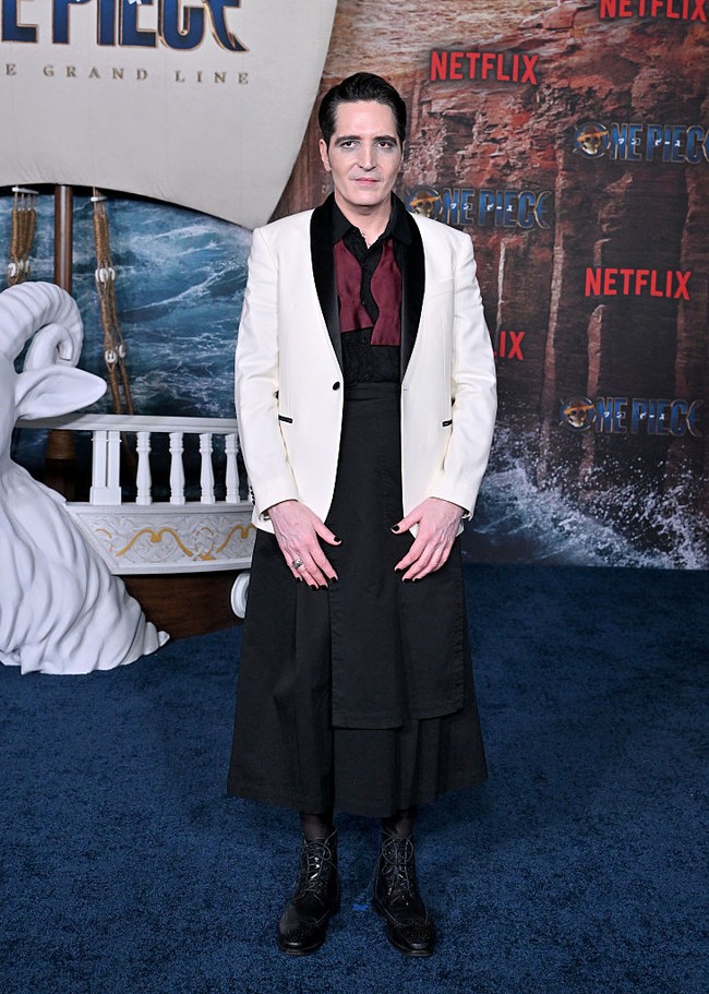 Aktor veteran David Dastmalchian, pemeran karakter Mr. 3, menampilkan gaya unik dan androginy dengan memadukan jas putih, blouse hitam dan rok panjang hitam. Foto: Getty Images